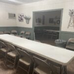 a long table in a room with metal chairs
